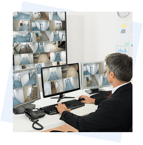 A man sitting at his computer desk in front of multiple monitors.