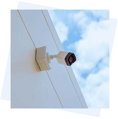 A white camera mounted to the side of a building.