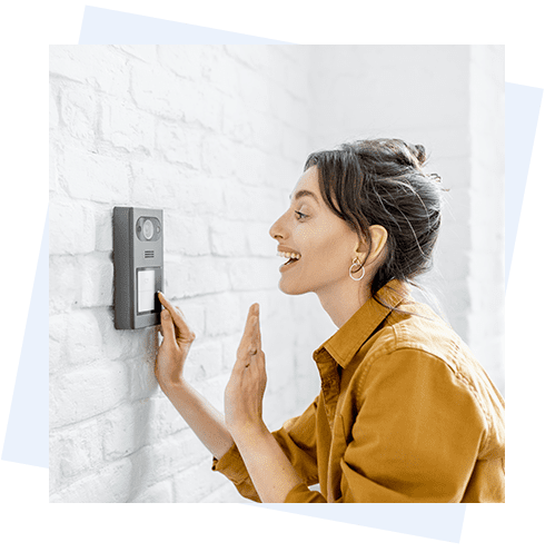 A woman is looking at the wall with her finger on it.