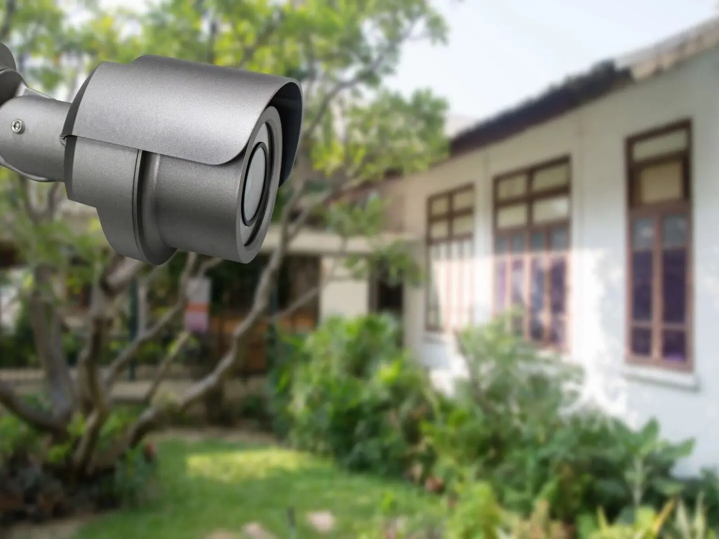 A camera is hanging outside of a house.