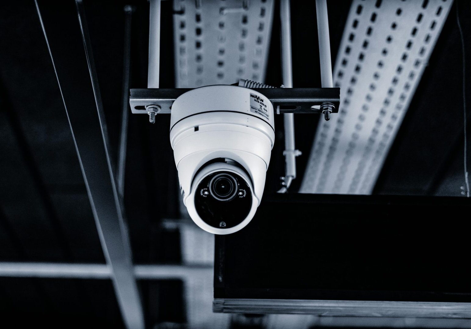 A camera hanging from the ceiling of an industrial building.